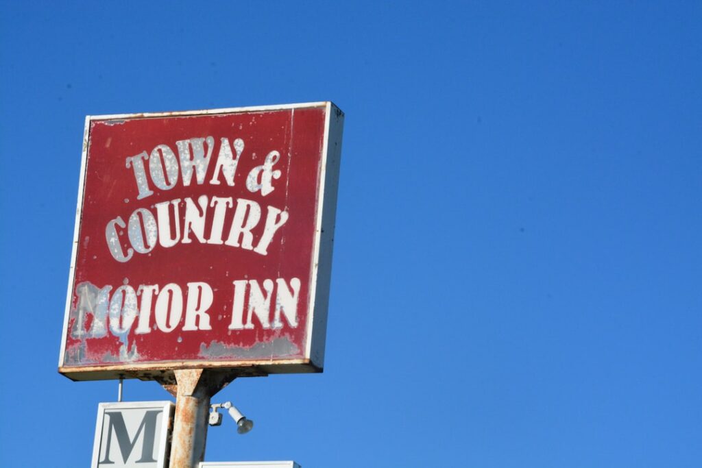 Residential house with a 'For Sale' sign in the front yard.