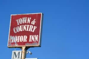 Residential house with a 'For Sale' sign in the front yard.
