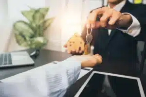 Real-estate-and-selling-house-concept--bank-agent-give-key-of-home-to-customer-after-successful-contract-signing-176699927...