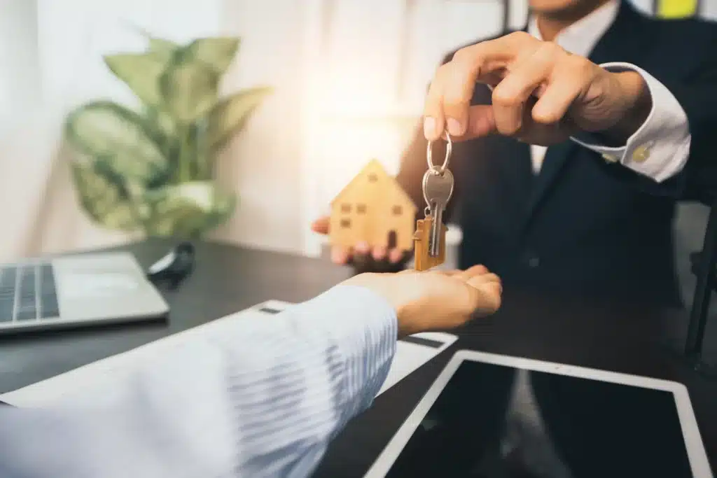 Real estate and selling house concept bank agent give key of home to customer after successful contract signing 1766999270209