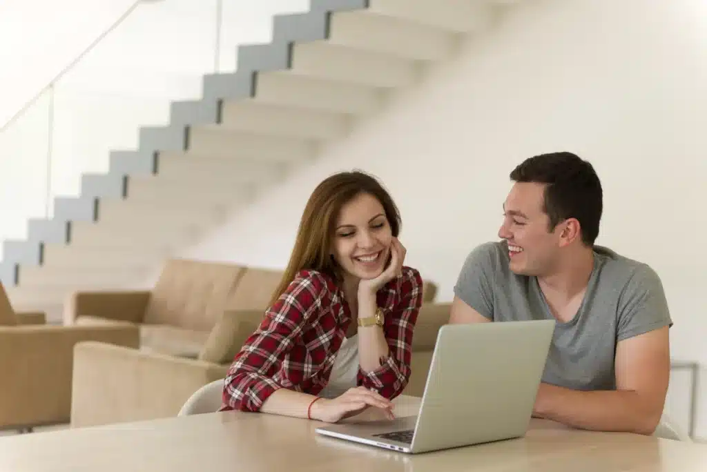 Happy-young-couple-buying-online-using-laptop-a-computer-and-a-credit-card-in-their-luxury-home-villa-1766999199017.webp