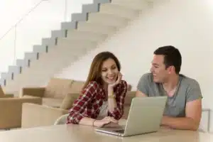 Happy-young-couple-buying-online-using-laptop-a-computer-and-a-credit-card-in-their-luxury-home-villa-1766999199017.webp