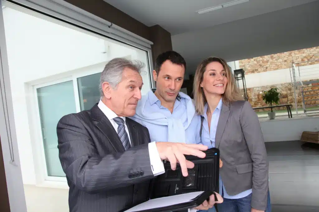 Real estate agent showing modern house to couple
